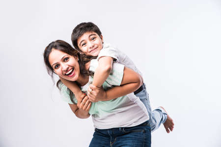 Portrait of Indian young mother and son against white background, looking at cameraの写真素材