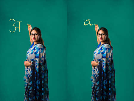 Portrait of Indian lady teacher in saree stands against green, white or blackboard , conducting...