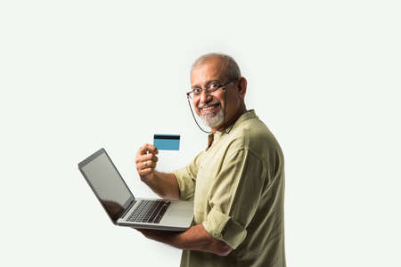 Senior IAsian Indian Adult Holding Laptop with Credit Card, online shopping or e-commerce Concept