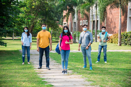 Asian Indian students wears face mask and follow social distancing norms in college or university...