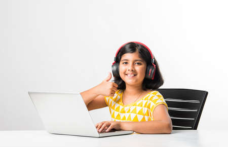 Pretty stylish Indian asian schoolgirl studying attending online lesson at home, social distance during quarantine, self-isolation, online education concept, home schoolerの写真素材