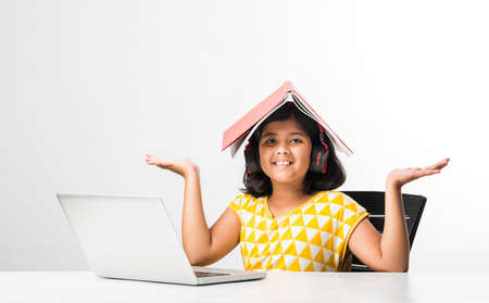Pretty stylish Indian asian schoolgirl studying attending online lesson at home, social distance...