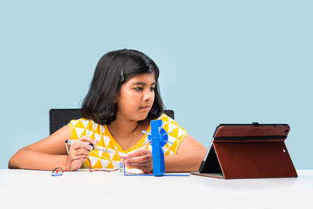 electronic experiment - Asian Indian small girl student performing windmill research with wires,...
