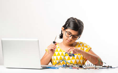 electronic experiment - Asian Indian small girl student performing or studying science with wires,...
