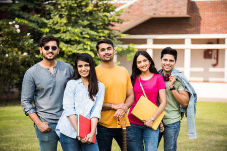 Cheerful Indian asian young group of college students or friends laughing together while sitting,...