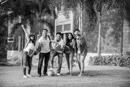 Cheerful Indian asian young group of college students or friends laughing together while sitting,...