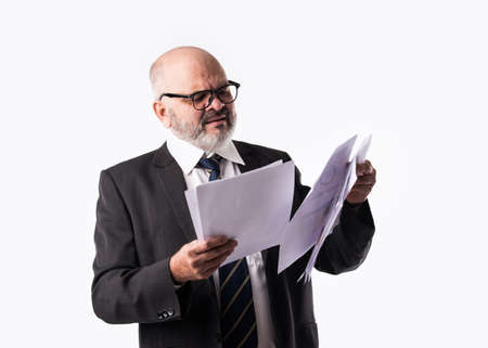 Portrait of Indian asian senior businessman holding or reading paper documents while standing...
