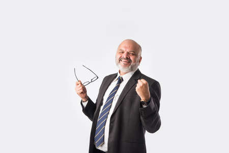 Portrait of an Asian Indian senior business man enjoying or celebrating success, screaming or with...