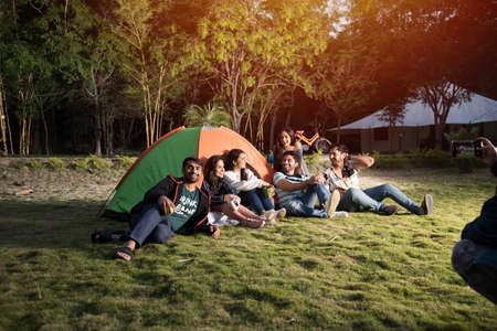 Asian Indian young friends have good time on camping trip, relaxing vacation with fun outside tentsの写真素材
