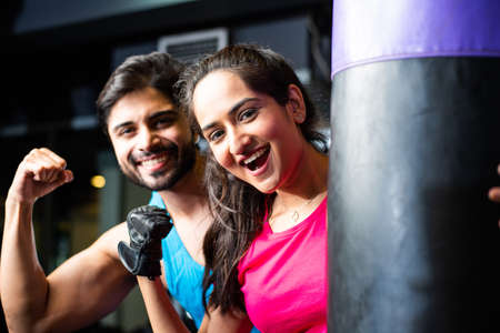 Indian asian Young couple boxing in the gym. Attractive woman and handsome fit man are training in modern gym - health and fitness conceptの写真素材