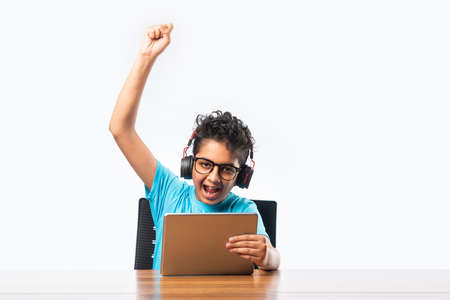 Indian asian school kid using tablet computer for playing or studyingの写真素材