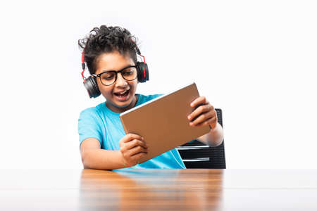 Indian asian school kid using tablet computer for playing or studying