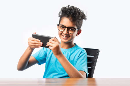Indian asian small boy or kid using smartphone for gaming or for educationの写真素材