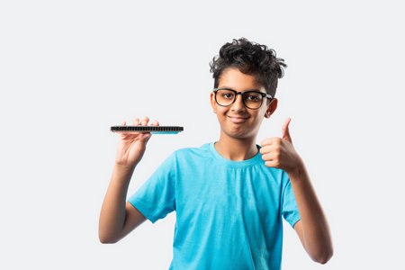 Indian asian little boy playing harmonica or mouth organ, early learning conceptの写真素材