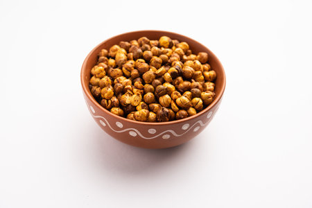 Spicy crispy roasted or fried chickpeas or futana with paprika, selective focus. Tasty popular vegetarian snack or side dish or chakna consumed with cocktail drinksの写真素材