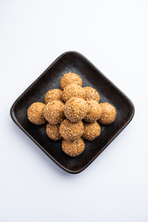 Sesame seed jaggery ball or til ke laddo and tilgul or til gul laddu served in bowl for Makar Sankranti Festival in Indiaの写真素材