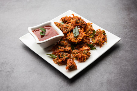 Carrot Fritters or Gajar ke pakore or pakode or bajji or bhaji, Indian snack served in a plate with tomato ketchupの写真素材