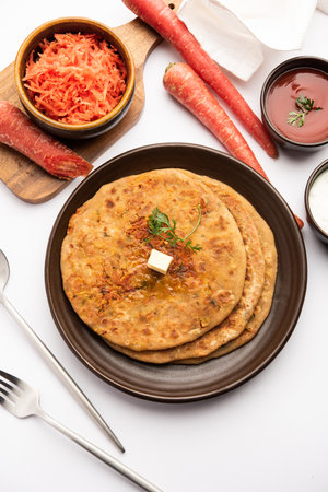 Carrot or gajar ka parathaÂ is a Punjabi dish which is an Indian unleavened flatbread made with whole wheat flour andÂ carrot. Served with ketchup and curdの写真素材