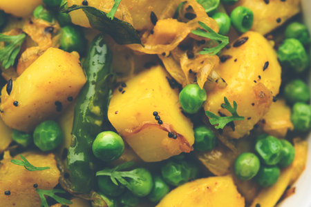 Aloo Mutter or Matar aalu dry sabzi, Indian Potato and green Peas fried together with spices and garnished with coriander leaves. served with roti or chapatiの写真素材