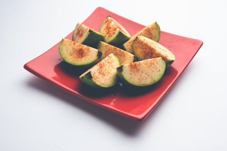 Fresh sliced guavaÂ orÂ Jaam or peru sprinkled with a little bitÂ salt, redÂ chilliÂ powderの写真素材