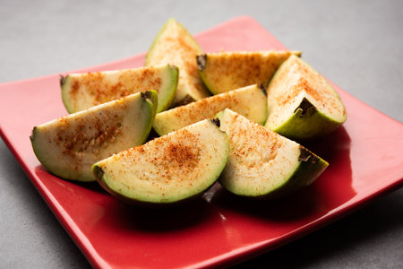 Fresh sliced guavaÂ orÂ Jaam or peru sprinkled with a little bitÂ salt, redÂ chilliÂ powderの写真素材