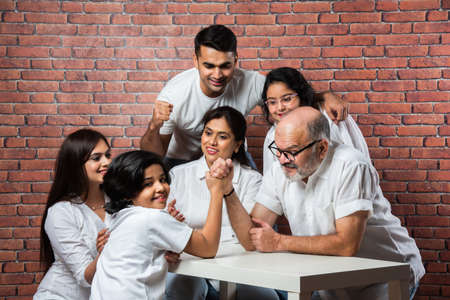 Multigenerational Indian asian family with white board, pointing or presenting empty white placardの写真素材