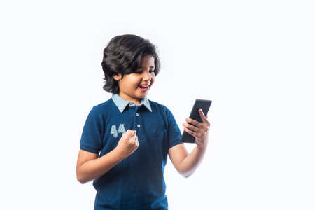 Indian kid using smartphone or mobile phone while wering glasses, with success or sad expressionsの写真素材