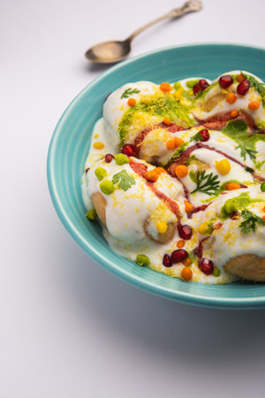 Dahi vada or bhalla is a type of chaat originating from the Indian and popular throughout South Asia. It is prepared by soaking vadas in thick dahi or curd. selective focusの写真素材
