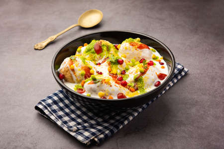 Dahi vada or bhalla is a type of chaat originating from the Indian and popular throughout South Asia. It is prepared by soaking vadas in thick dahi or curd. selective focusの写真素材