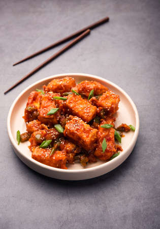 CrispyÂ chilli paneerÂ is a Indo Chinese starter or appetizer made by tossing fried cottage cheese in sweet sour and spicy chilli sauce, served in a plate. selective focusの写真素材