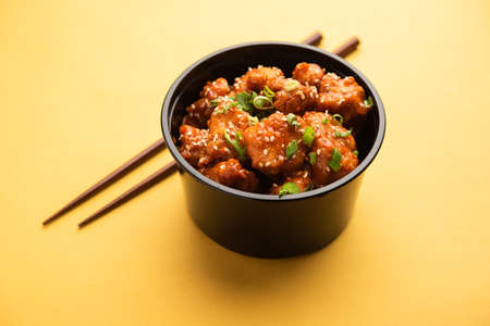 Chilli Chicken is packed in a black plastic container for online food delivery orderの写真素材