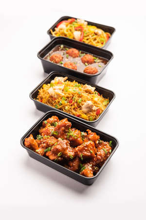 Group of home delivered Indo Chinese food in plastic packages, containersÂ or boxes containingÂ schezwan noodles, fried rice, chilli chicken, manchurian and soup. Online food ordering concept in Indiaの写真素材
