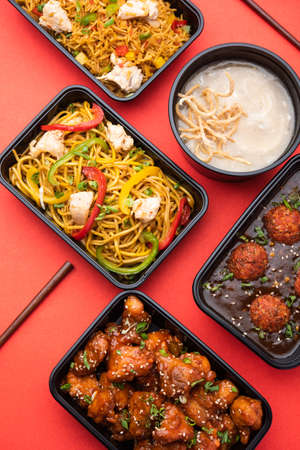 Group of home delivered Indo Chinese food in plastic packages, containersÂ or boxes containingÂ schezwan noodles, fried rice, chilli chicken, manchurian and soup. Online food ordering concept in Indiaの写真素材
