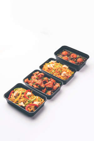 Group of home delivered Indo Chinese food in plastic packages, containersÂ or boxes containingÂ schezwan noodles, fried rice, chilli chicken, manchurian and soup. Online food ordering concept in Indiaの写真素材