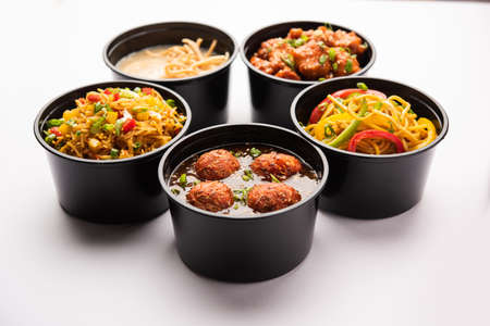 Group of home delivered Indo Chinese food in plastic packages, containersÂ or boxes containingÂ schezwan noodles, fried rice, chilli chicken, manchurian and soup. Online food ordering concept in Indiaの写真素材