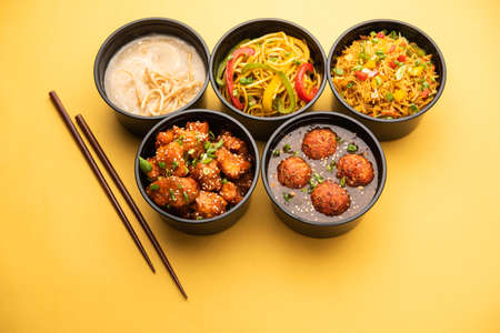 Group of home delivered Indo Chinese food in plastic packages, containersÂ or boxes containingÂ schezwan noodles, fried rice, chilli chicken, manchurian and soup. Online food ordering concept in Indiaの写真素材
