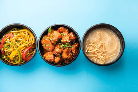 Group of home delivered Indo Chinese food in plastic packages, containersÂ or boxes containingÂ schezwan noodles, fried rice, chilli chicken, manchurian and soup. Online food ordering concept in Indiaの写真素材