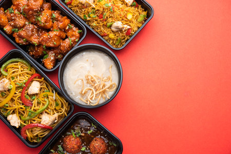 Group of home delivered Indo Chinese food in plastic packages, containersÂ or boxes containingÂ schezwan noodles, fried rice, chilli chicken, manchurian and soup. Online food ordering concept in Indiaの写真素材