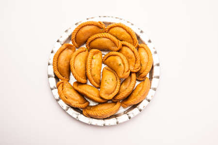 Gujiya or gujia or karanji - sweet dumplings made during the festival of holi and diwali, served in a plate. selective focusの写真素材