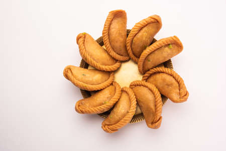 Gujiya or gujia or karanji - sweet dumplings made during the festival of holi and diwali, served in a plate. selective focusの写真素材