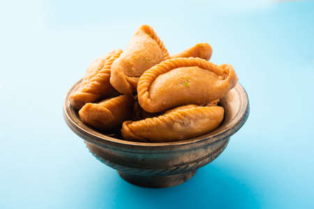 Gujiya or gujia or karanji - sweet dumplings made during the festival of holi and diwali, served in a plate. selective focusの写真素材