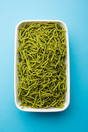 Spinach or palak sev are crunchy fried savory noodles. Homemade Thick and thin greenÂ shev or namkeen is a classic Indian snack. served in a bowl or plateの写真素材