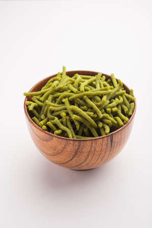 Spinach or palak sev are crunchy fried savory noodles. Homemade Thick and thin greenÂ shev or namkeen is a classic Indian snack. served in a bowl or plateの写真素材