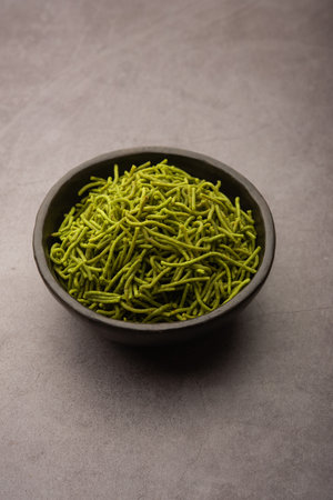 Spinach or palak sev are crunchy fried savory noodles. Homemade Thick and thin greenÂ shev or namkeen is a classic Indian snack. served in a bowl or plateの写真素材