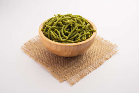 Spinach or palak sev are crunchy fried savory noodles. Homemade Thick and thin greenÂ shev or namkeen is a classic Indian snack. served in a bowl or plateの写真素材