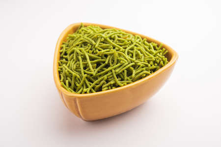 Spinach or palak sev are crunchy fried savory noodles. Homemade Thick and thin greenÂ shev or namkeen is a classic Indian snack. served in a bowl or plateの写真素材