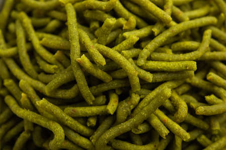 Spinach or palak sev are crunchy fried savory noodles. Homemade Thick and thin greenÂ shev or namkeen is a classic Indian snack. served in a bowl or plateの写真素材