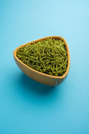 Spinach or palak sev are crunchy fried savory noodles. Homemade Thick and thin greenÂ shev or namkeen is a classic Indian snack. served in a bowl or plateの写真素材