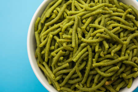 Spinach or palak sev are crunchy fried savory noodles. Homemade Thick and thin greenÂ shev or namkeen is a classic Indian snack. served in a bowl or plateの写真素材