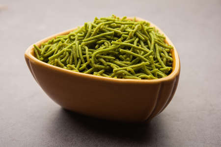 Spinach or palak sev are crunchy fried savory noodles. Homemade Thick and thin greenÂ shev or namkeen is a classic Indian snack. served in a bowl or plateの写真素材
